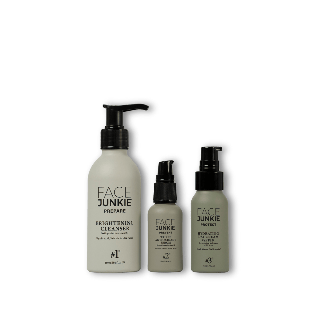 A set of three Face Junkie skincare products displayed against a transparent background. The collection includes a Brightening Cleanser (